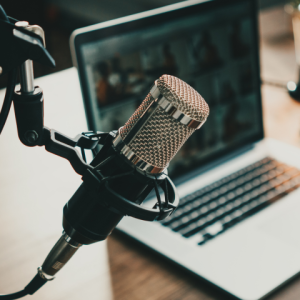 Microphone next to a laptop, illustrating that Exposure Therapy Designs hosts a podcast to help you on your healing journey.