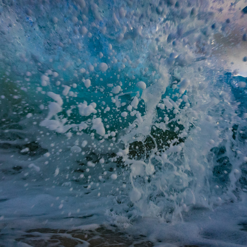 Dynamic ocean wave captured at the moment of crashing, its force and motion frozen in time, evoking the therapeutic power of nature akin to the transformative experiences facilitated by Exposure Therapy Designs.